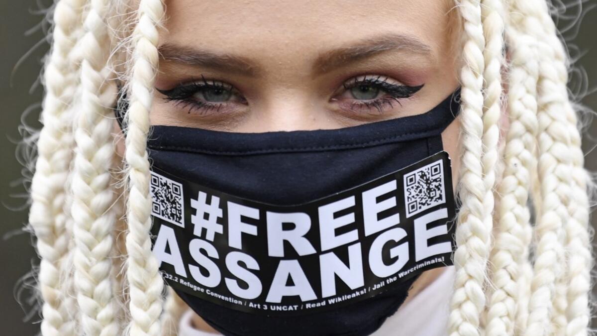 Nina from Amsterdam, a supporter of WikiLeaks founder Julian Assange, wears a face mask called for Assange's freedom as she poses for a photograph outside Woolwich Crown Court in southeast London on February 24, 2020, on the day of the opening of the full hearing into a US request for Assange's extradition. A British court on February 24 starts hearing Washington's extradition request for WikiLeaks founder Julian Assange in a test case of media freedoms in the digital age and the global limits of US justice