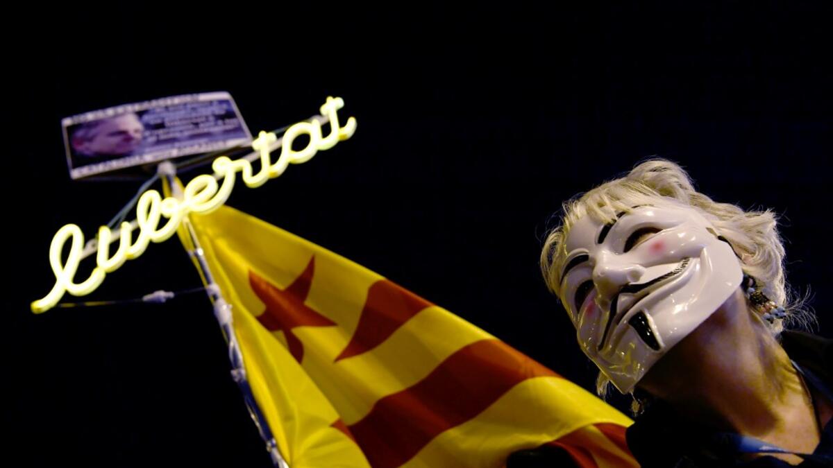 A demonstrator sporting a Guy Fawkes mask takes part in a protest called by Catalan National Assembly (ANC) under the motto "Journalism is not a crime" to support WikiLeaks founder Julian Assange in Barcelona on February 24, 2020. A British court today started hearing Washington's extradition request for WikiLeaks founder Julian Assange in a test case of media freedoms in the digital age and the global limits of US justice. LLUIS GENE / AFP