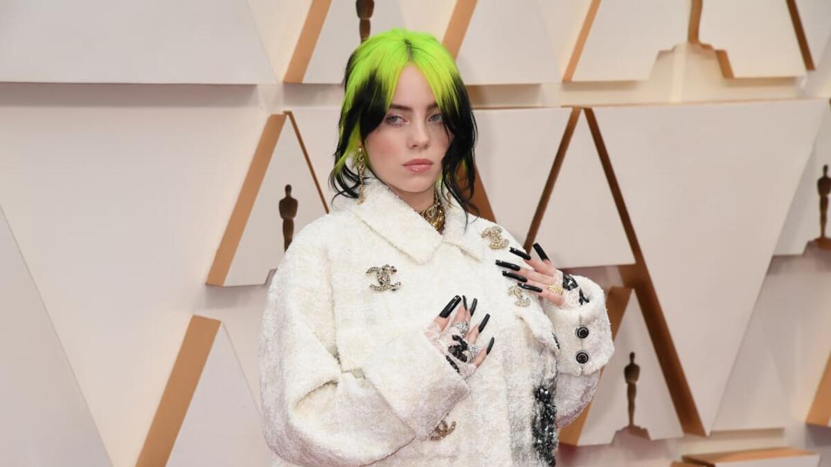Billie Eilish in a white-on-white houndstooth set, with a jacket featuring the Chanel's interlocking "C" logo