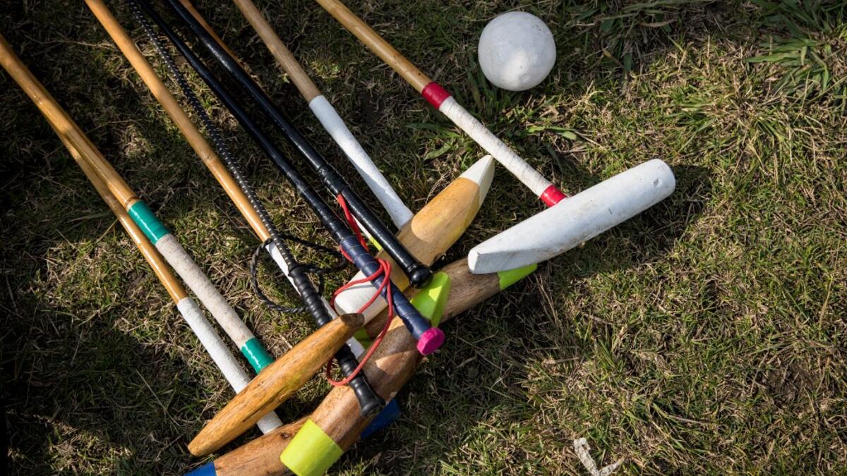 In this photograph taken on January 7, 2020, polo mallets and riding crops belonging to Linthoingambi Kangjei Lup polo club players lay on the grass before the start of their first match of the 15th Women's State Polo Tournament at the Mapal Kangjeibung (Polo Ground) in Imphal, the capital of the northeastern Indian state of Manipur. Laishram Thadoi's face is a picture of concentration as she adjusts her helmet and prepares to play in Manipur, the remote Indian state regarded as the birthplace of modern pol
