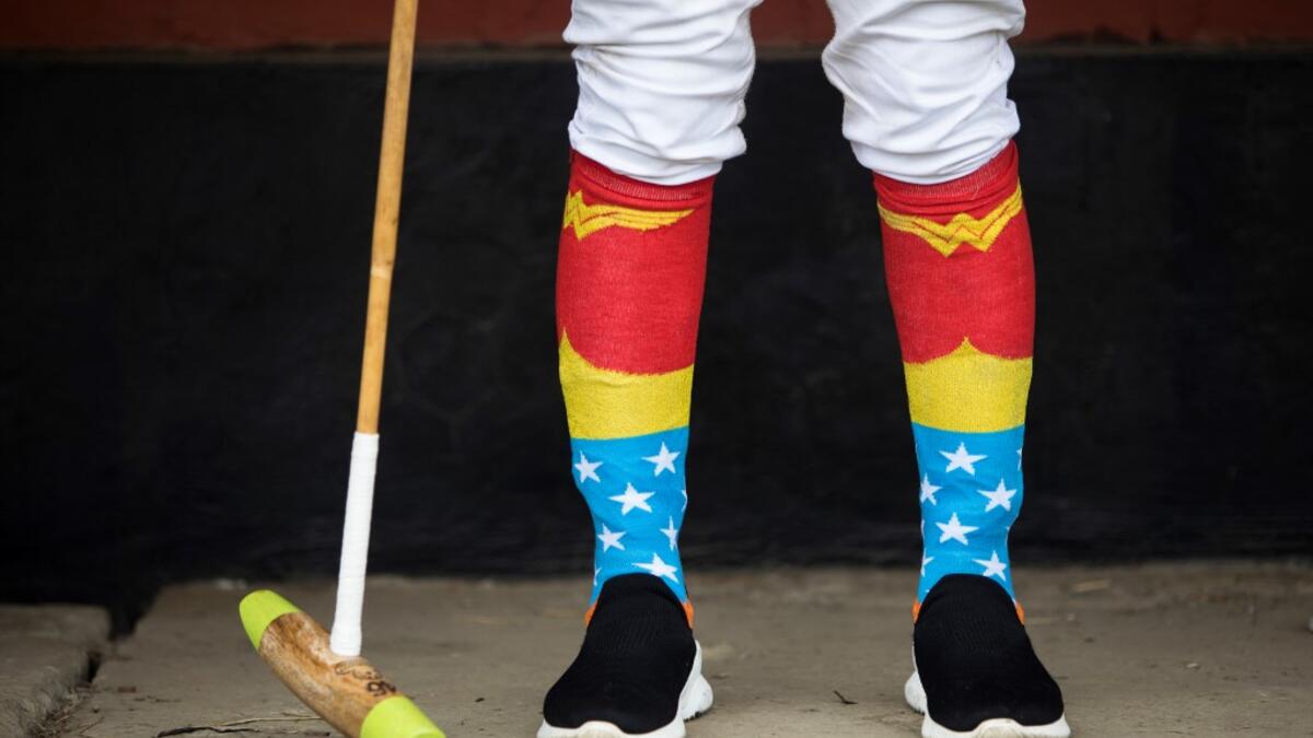 In this photograph taken on January 9, 2020, Linthoingambi Kangjei Lup Polo Club player Khundongbam Dementy, wearing a pair of 'Wonder Woman' socks, follows a match from the sidelines at the Mapal Kangjeibung (Polo Ground) in Imphal, the capital of the northeastern Indian state of Manipur. Laishram Thadoi's face is a picture of concentration as she adjusts her helmet and prepares to play in Manipur, the remote Indian state regarded as the birthplace of modern polo. Xavier GALIANA / AFP