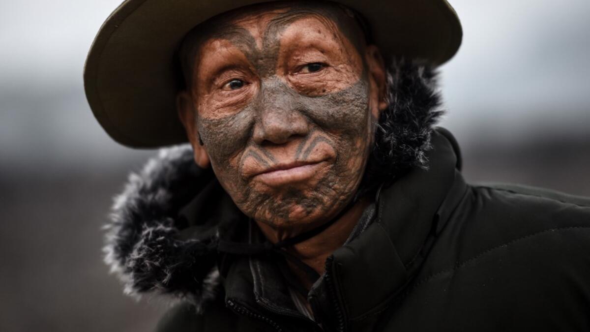 This photo taken on February 8, 2020 shows Houn Ngo Kaw, 75, a tattooed Konyak tribeman, at Longwa village in Sagaing region of Myanmar, wedged in a semi-autonomous zone near the Indian border. People in the region subscribe to a complex patchwork of customs, intertwining their animist beliefs with warrior traditions that include striking tattoo designs, which can signify tribal identity, life accomplishments or the completion of a rite of passage. Ye Aung THU / AFP
