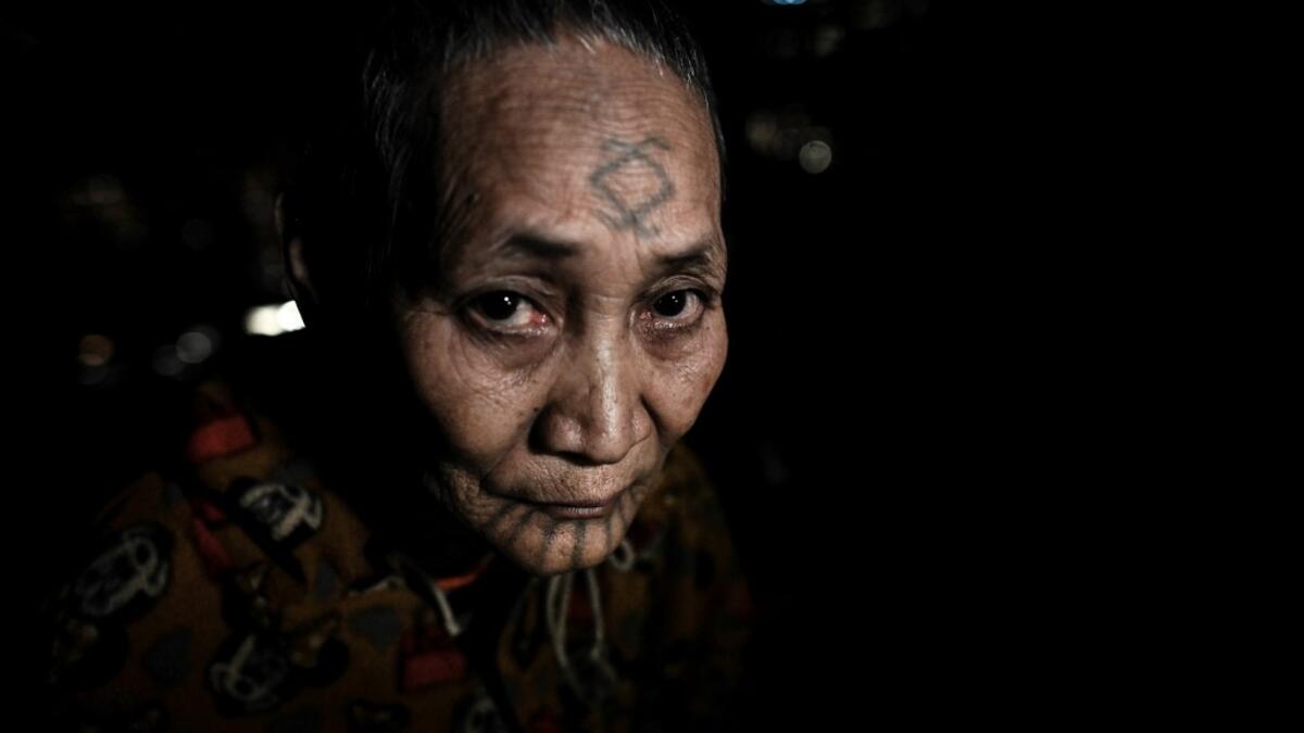 This photo taken on February 6, 2020 shows Khamyo Pon Nyun, 75, a tattooed Lainong tribeswoman resting at her house at Lahel township in Sagaing region of Myanmar, wedged in a semi-autonomous zone near the Indian border. People in the region subscribe to a complex patchwork of customs, intertwining their animist beliefs with warrior traditions that include striking tattoo designs, which can signify tribal identity, life accomplishments or the completion of a rite of passage. Ye Aung THU / AFP