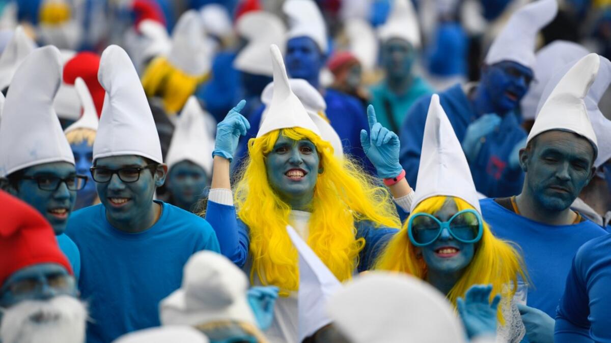 People dressed as Smurfs ('Schtroumpfs' in French), a Belgian comic franchise centered on a fictional colony of small, blue, human-like creatures who live in mushroom-shaped houses in the forest, attend a world record gathering of Smurfs on March 7, 2020, in Landerneau, western France. Damien MEYER / AFP