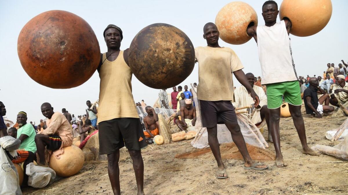 Fishermen carry calabashes to attend Argungu fishing and cultural festival at Argungu Town, Kebbi State in northwestern Nigeria, on March 14, 2020. Argungu fishing and cultural festival is one of the oldest and most widely attended festivals in the country dating back many generations, featuring series of water competitions and traditional games. The festival returned after 10 years suspension due to insecurity in northwest Nigeria. PIUS UTOMI EKPEI / AFP