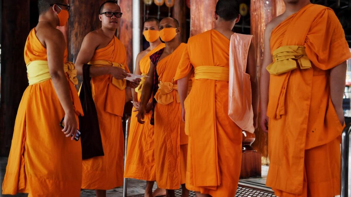 Buddhist monks wear face masks amid concerns over the spread of the COVID-19 coronavirus at Wat Pak Nam Buddhist temple in Bangkok on March 16, 2020. Lillian SUWANRUMPHA / AFP