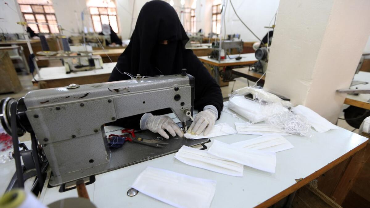 A Yemeni woman makes face masks at a textile factory in the capital Sanaa on March 16, 2020. More than a decade after it shut down, 20 women have brought back to life Yemen's oldest industrial factory to manufacture what could save many lives amid a global pandemic: masks. Mohammed HUWAIS / AFP