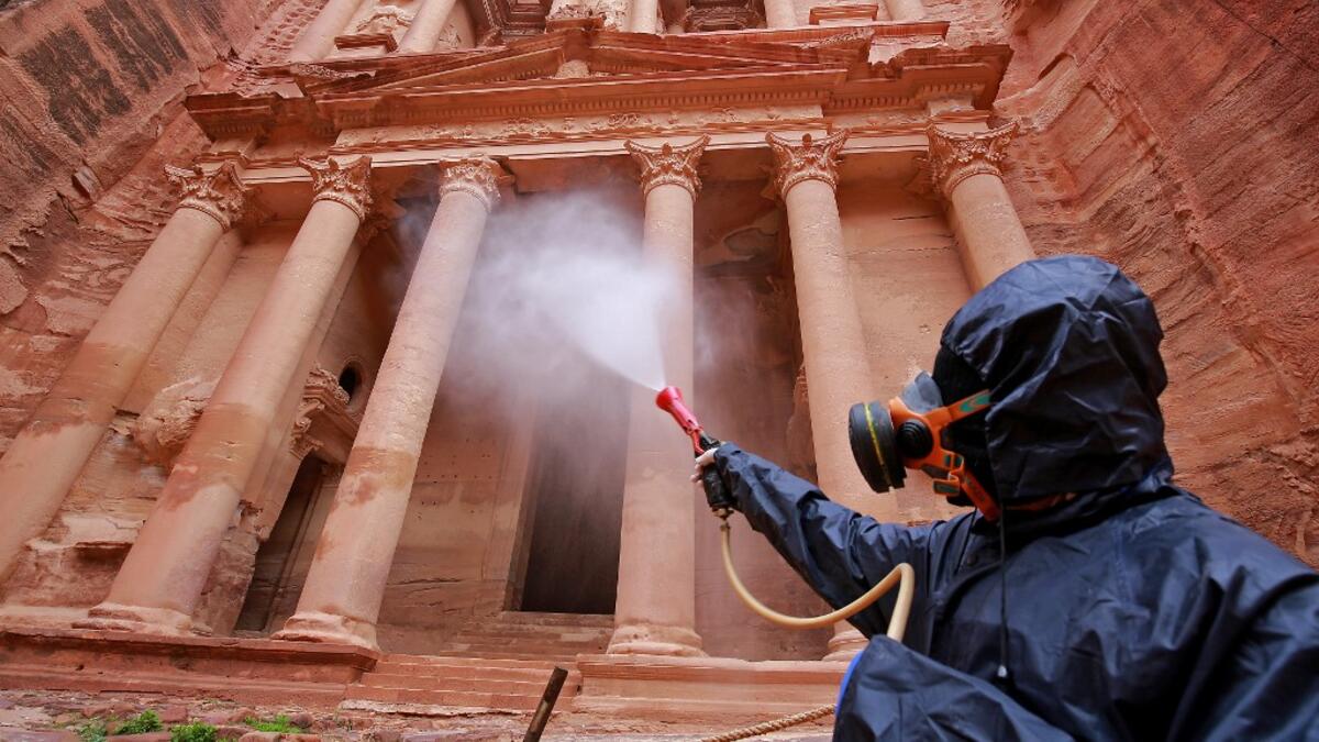 A labourer sprays disinfectant in Jordan's archaeological city of Petra south of the capital Amman on March 17, 2020, to prevent the spread of COVID-19. Khalil MAZRAAWI / afp