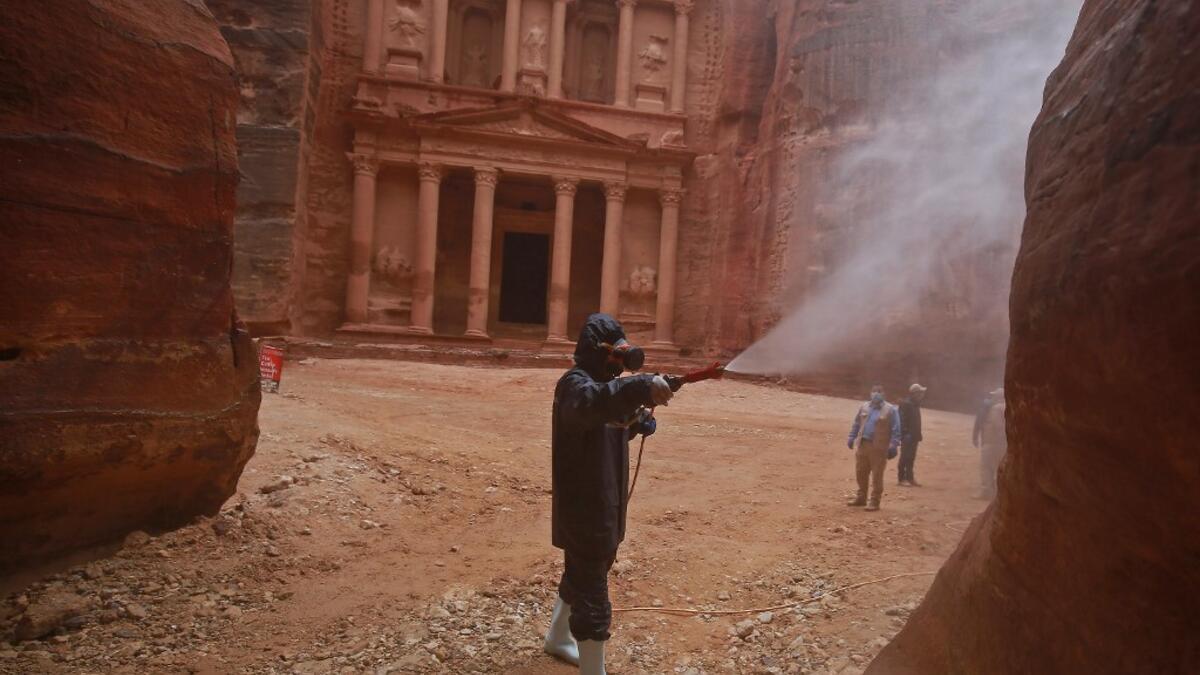 A labourer sprays disinfectant in Jordan's archaeological city of Petra south of the capital Amman on March 17, 2020, to prevent the spread of COVID-19. Khalil MAZRAAWI / afp