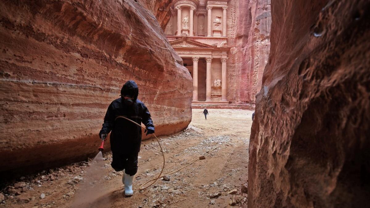 A labourer sprays disinfectant in Jordan's archaeological city of Petra south of the capital Amman on March 17, 2020, to prevent the spread of COVID-19. Khalil MAZRAAWI / afp