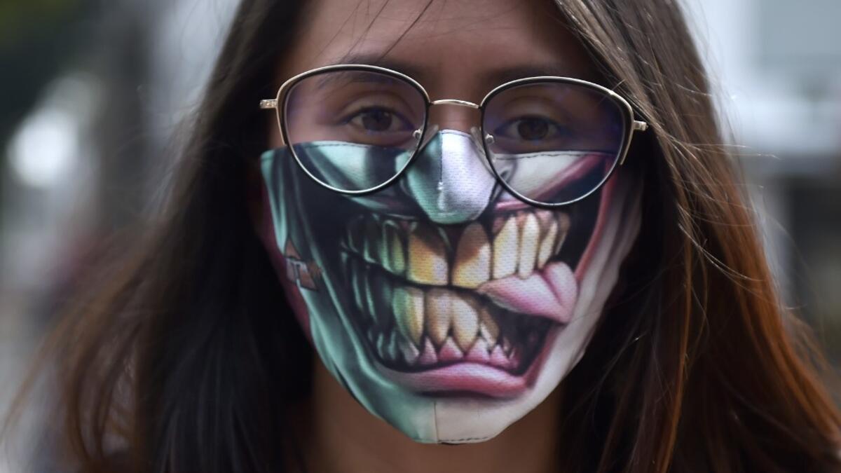 A woman uses a face masks as a preventive measure against the spread of the new coronavirus, COVID-19, in Bogota, on March 19, 2020. Colombia will block all international flights from Monday for 30 days, President Ivan Duque announced on Thursday. Raul ARBOLEDA / AFP
