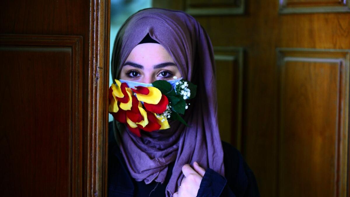 A woman is seen wearing a mask embellished with petals in the central Iraqi holy city of Najaf on March 21, 2020 amid the COVID-19 coronavirus pandemic. Haidar HAMDANI / AFP