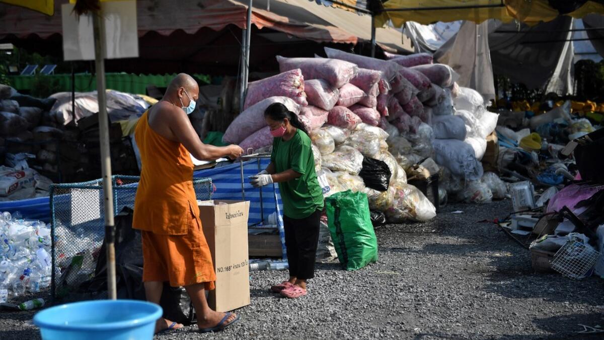A Buddhist monk sorts salvaged plastic bottles to be recycled into monks’robes and face masks, amid concerns over the spread of the COVID-19 coronavirus, at Wat Chak Daeng Buddhist temple in Samut Prakan on March 23, 2020. The plastic wastes are sent to a separate recycling facility processing it into thread materials and woven as special fabric for monks. Lillian SUWANRUMPHA / AFP