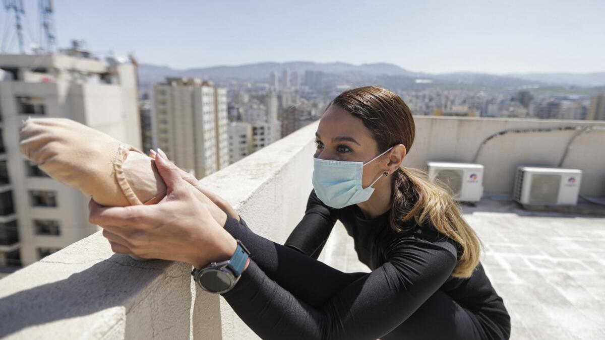 Sherazade Mami, a 28-year-old Tunisian professional dancer and performer at the Caracalla dance theatre and a teacher at the Caracalla dance school, practices while wearing a surgical mask on the roof of her apartment building in the suburb of Dekwaneh on the eastern outskirts of Lebanon's capital Beirut on April 4, 2020. Due to the confinement regulations imposed to combat the COVID-19 coronavirus pandemic, Mami opted to continue practicing on her rooftop to remain in shape. JOSEPH EID / AFP