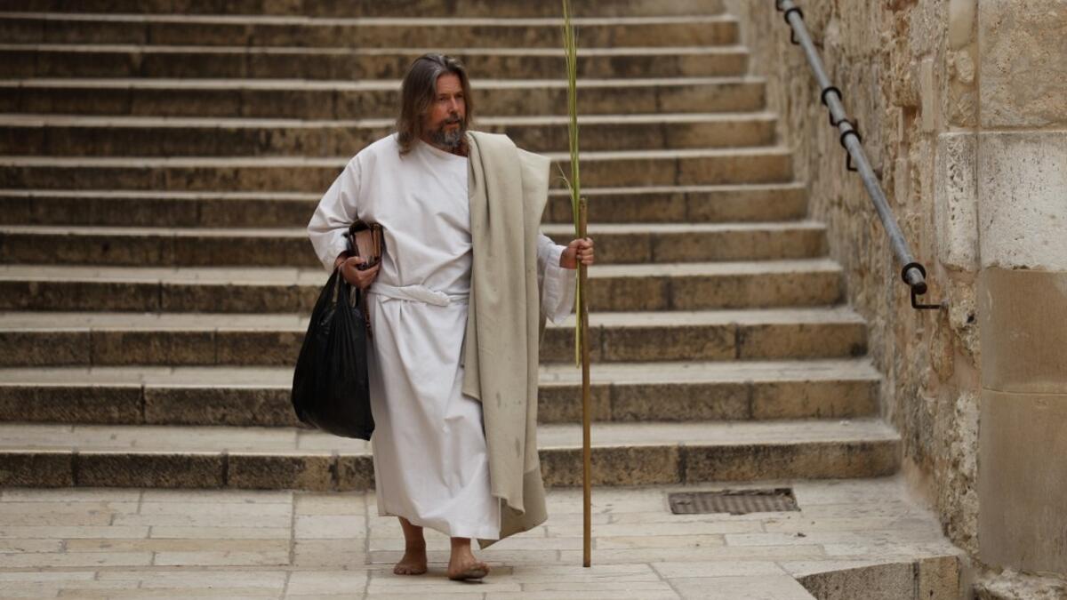 A worshipper arrives to pray outside the closed door of the Holy Sepulchre Church on Palm Sunday in Jerusalem's Old City amid movement restrictions due to the COVID-19 coronavirus pandemic, on April 5 2020. Ahmad GHARABLI / AFP