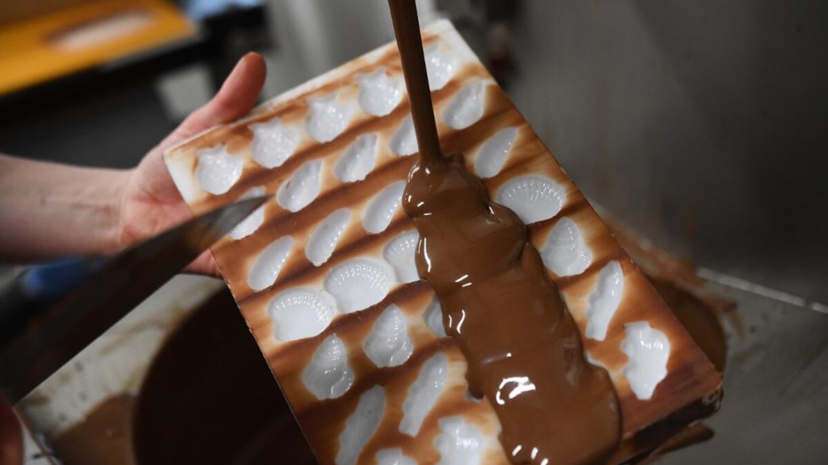 A French chocolate maker fills moulds with chocolate in the workshop 'Atelier N° 5' in La Foret-Fouesnant, western France on April 7, 2020, ahead of the Christian Festival of Easter. Fred TANNEAU / AFP