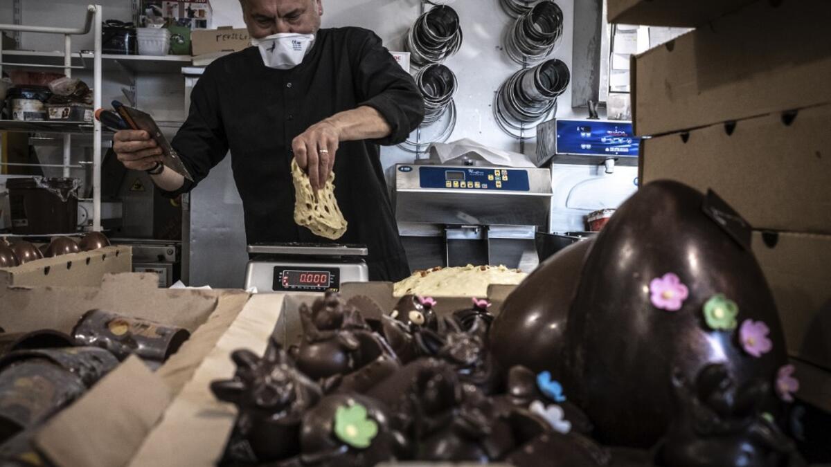 An employee of pastry and chocolate maker Didier Girard prepares Easter chocolate before delivering them at clients' homes in Vourles, near Lyon at on April 7, 2020, on the twenty-second day of a strict lockdown in France to stop the spread of COVID-19, caused by the novel coronavirus. JEAN-PHILIPPE KSIAZEK / AFP