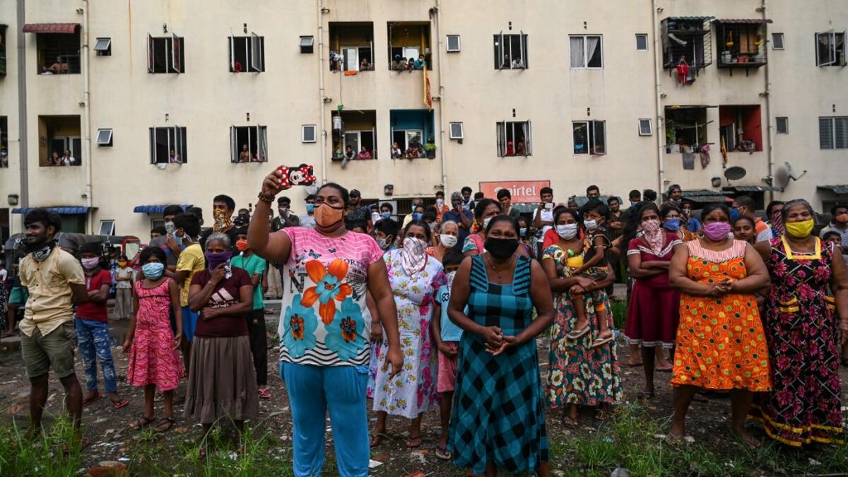 Residents watch a music band formed by Sri Lankan Navy personnel as they play outside a housing complex during a government-imposed nationwide lockdown as a preventive measure against the COVID-19 coronavirus, in Colombo on April 9, 2020. ISHARA S. KODIKARA / AFP