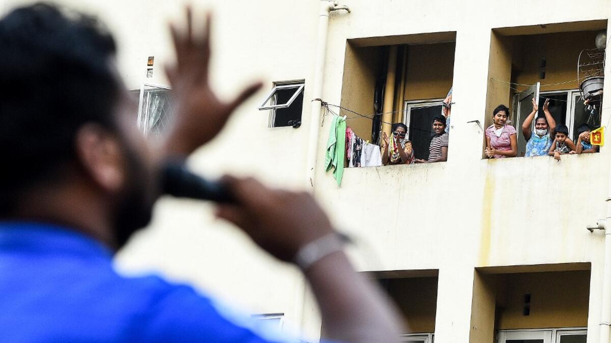 Residents watch from their flats' windows a music band formed by Sri Lankan Navy personnel as they play outside a housing complex during a government-imposed nationwide lockdown as a preventive measure against the COVID-19 coronavirus, in Colombo on April 9, 2020. ISHARA S. KODIKARA / AFP