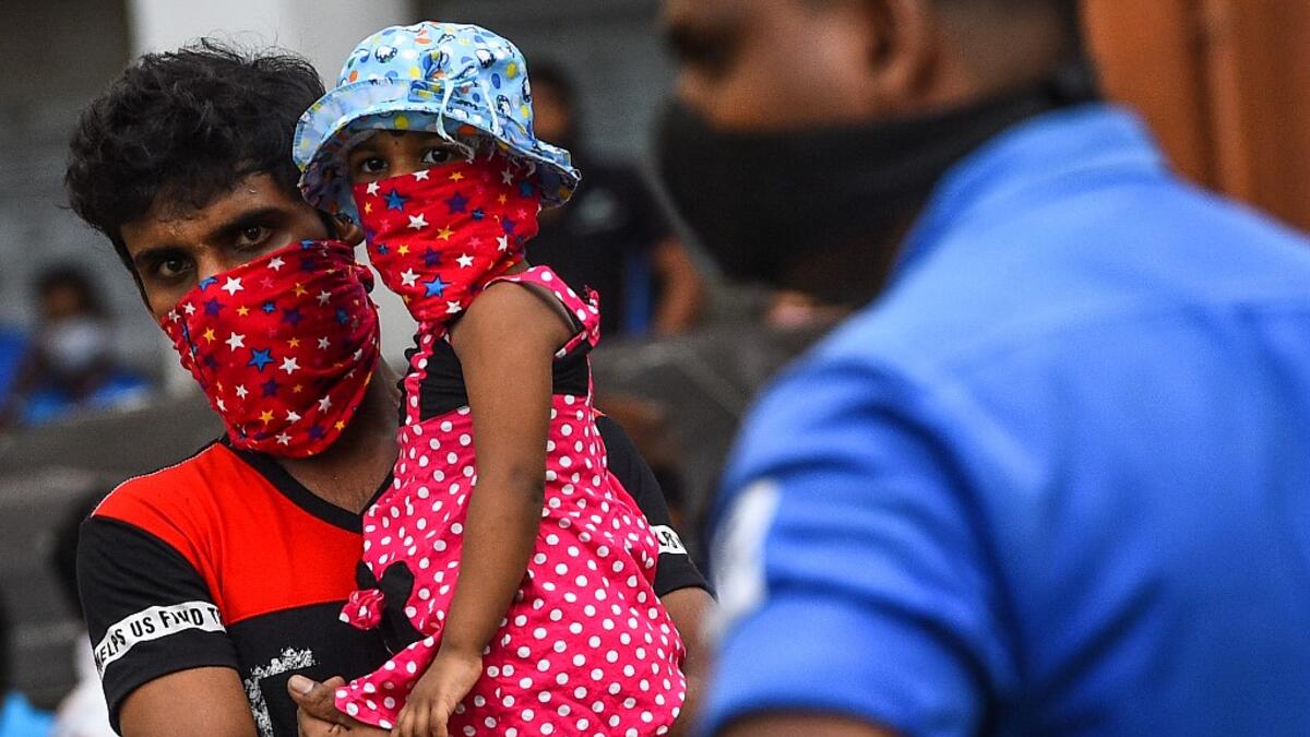 Residents watch a music band formed by Sri Lankan Navy personnel as they play outside a housing complex during a government-imposed nationwide lockdown as a preventive measure against the COVID-19 coronavirus, in Colombo on April 9, 2020. ISHARA S. KODIKARA / AFP