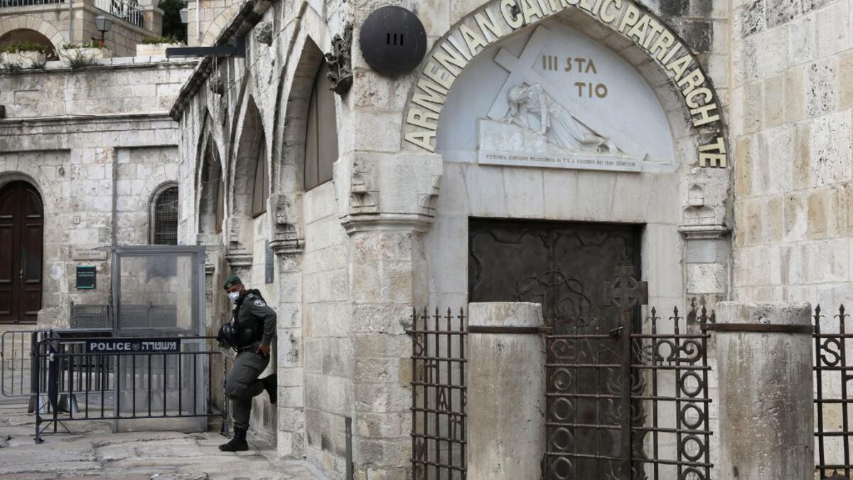 An Israeli border policeman wearing a protective mask stands guard by the third station of the Way of the Cross, also known as the Via Dolorosa, believed to be the route Jesus walked carrying the cross on the way to crucifixion, in Jerusalem's Old City, on April 7, 2020. All cultural sites in the Holy Land are shuttered, regardless of their religious affiliation, as authorities seek to forestall the spread of the deadly respiratory disease, which will prevent Christians from congregating for the Easter serv