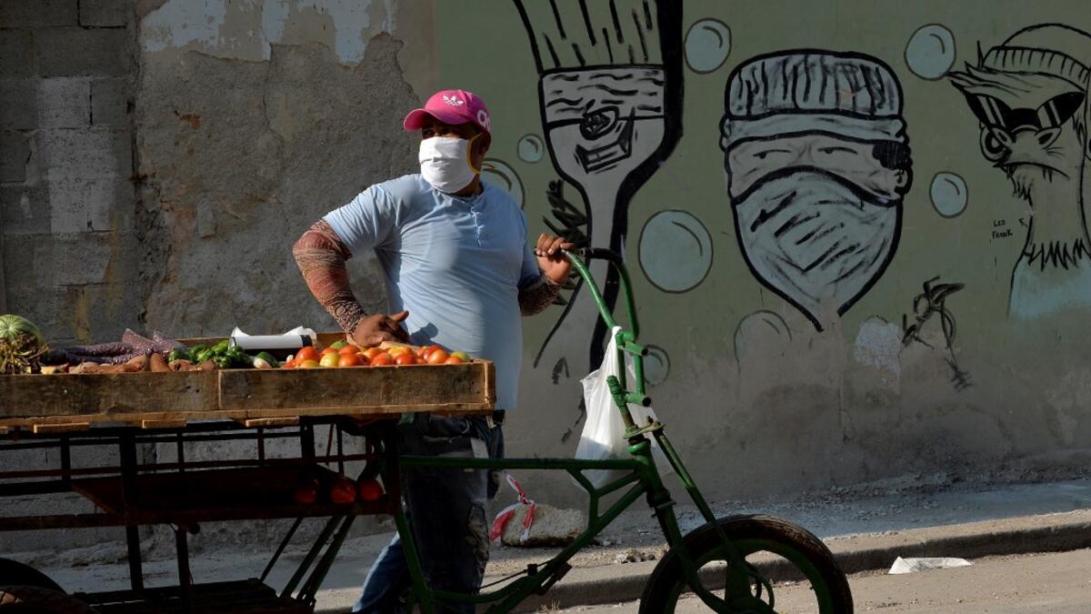 A fruits and vegetables seller wears a face mask in Havana, on April 11, 2020 amid the new coronavirus (COVID-19) pandemic. Cuba hit out at the United States on Friday over its nearly 60-year-old embargo against the island nation, which Havana described as "even more cruel" given the suffering caused by the new coronavirus pandemic. The communist-run single-party island is finding it tough to source medical supplies and has already recorded 620 coronavirus cases and 16 deaths. YAMIL LAGE / AFP