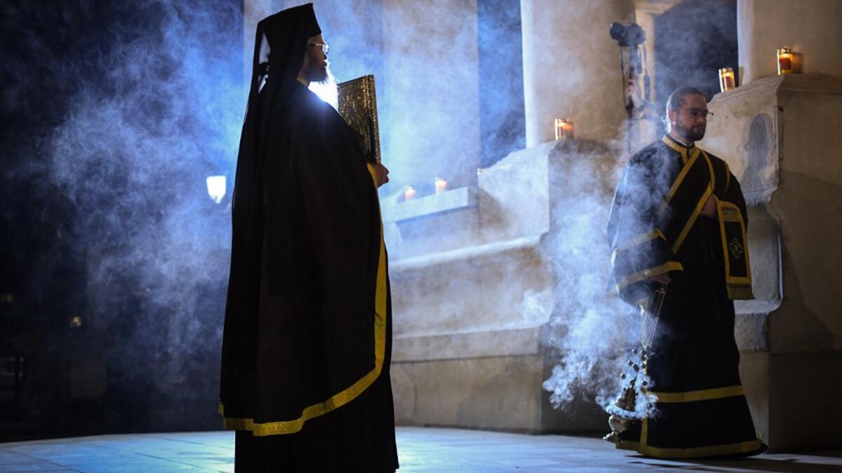 Romanian Christian Orthodox priests hold a religious service on the Good Friday, two days before Orthodox Easter celebration at the Patriarchal Cathedral in Bucharest April 17, 2020. Due to the emergency state called by the romanian authorities to slow down the coronavirus infection all the religious services will be held without believers inside or around the churches. Daniel MIHAILESCU / AFP