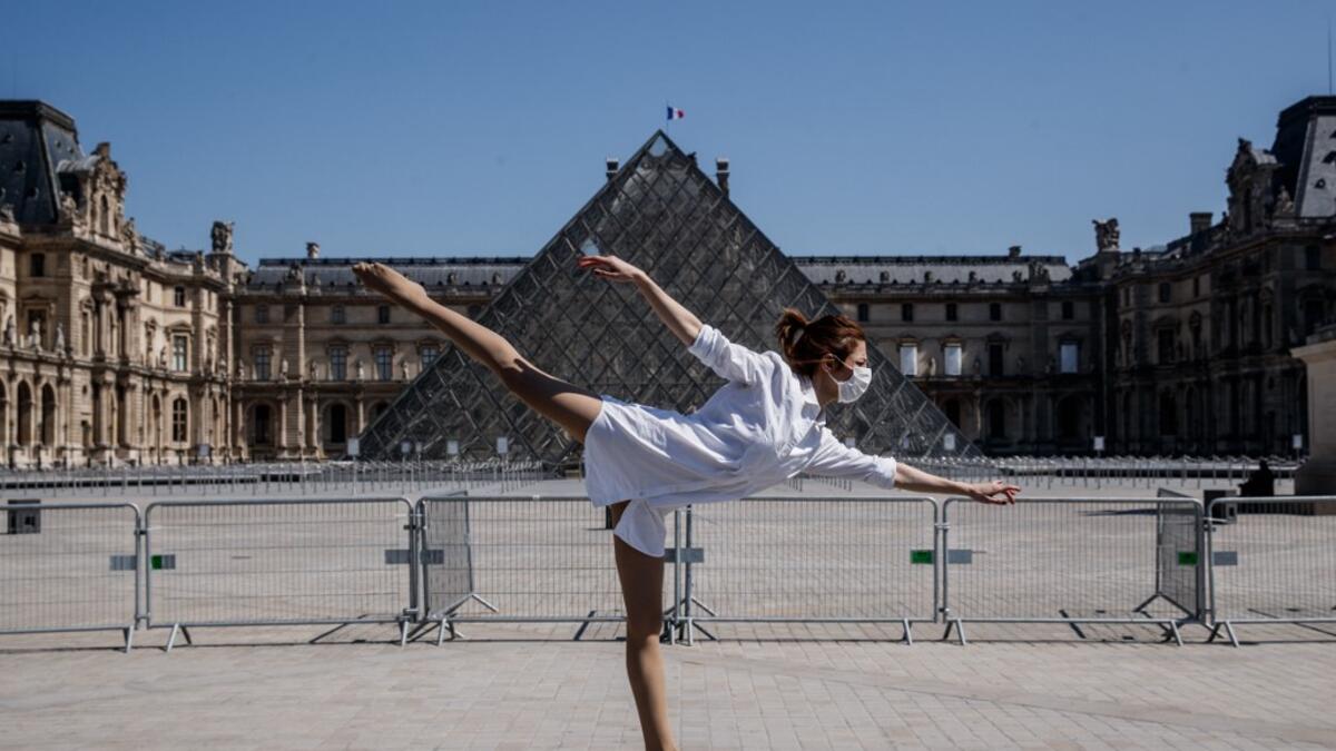 Syrian dancer and choreographer Yara al-Hasbani performs a dance in front the Louvre museum pyramid in Paris on April 22, 2020, on the 37th day of a strict lockdown in France to stop the spread of COVID-19 (novel coronavirus). Yara al-Hasbani was putting the finishing touches to her make-up for a performance of "Romeo and Juliet" in Damascus when she found out her father had been tortured to death. Sameer Al-DOUMY / AFP
