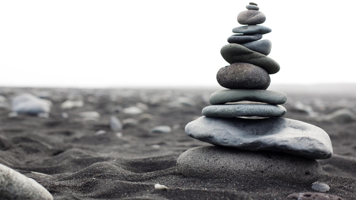 Pyramid from stones on the black sand beach in Iceland. The image close up  (Shutterstock)