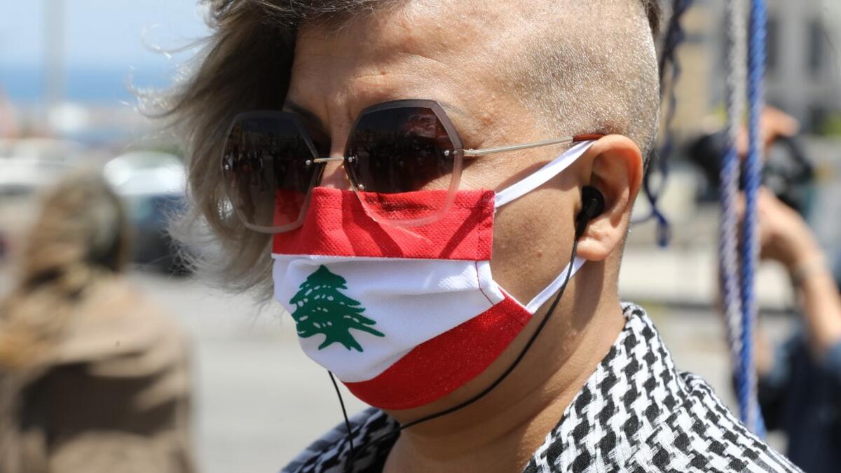 A Lebanese anti-government protester wearing a protective mask designed as a national flag amid the COVID-19 pandemic, takes part in a demonstration in downtown Beirut, on May 1, 2020, marking International Workers' Day (Labour Day). ANWAR AMRO / AFP