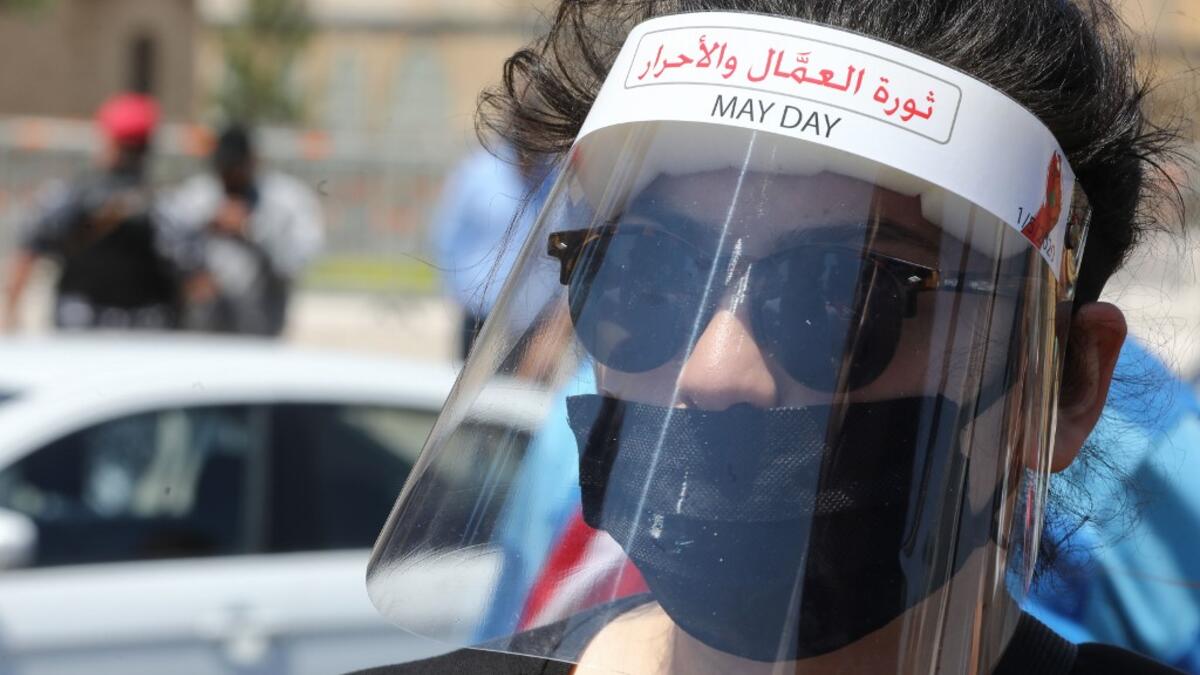 A Lebanese anti-government protester wearing protective gear amid the COVID-19 pandemic bearing the inscription "the revolution of the workers and of the free", takes part in a demonstration in downtown Beirut against the growing economic hardship, on May 1, 2020, marking International Workers' Day (Labour Day). ANWAR AMRO / AFP