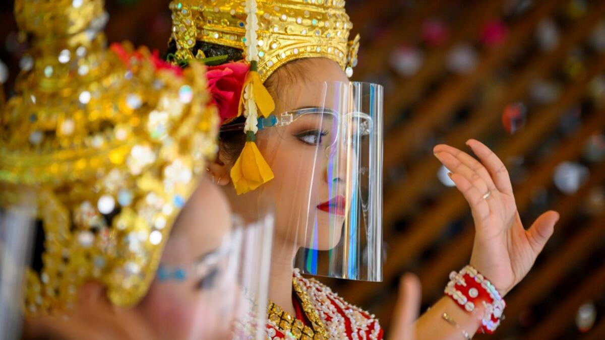 Traditional Thai dancers wearing protective face shields perform at the Erawan Shrine, which was reopened after the Thai government relaxed measures to combat the spread of the COVID-19 novel coronavirus, in Bangkok on May 4, 2020. Thailand began easing restrictions related to the COVID-19 novel coronavirus on May 3 by allowing various businesses to reopen, but warned that the stricter measures would be re-imposed should cases increase again. Mladen ANTONOV / AFP