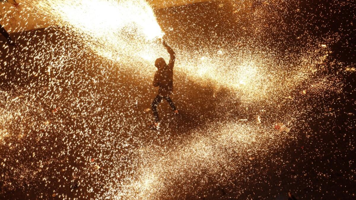 A Palestinian youth swings a homemade sparkler firework as people celebrate on a night of the Muslim holy month of Ramadan in Rafah refugee camp, in the southern Gaza Strip, on May 4, 2020. MAHMUD HAMS / AFP