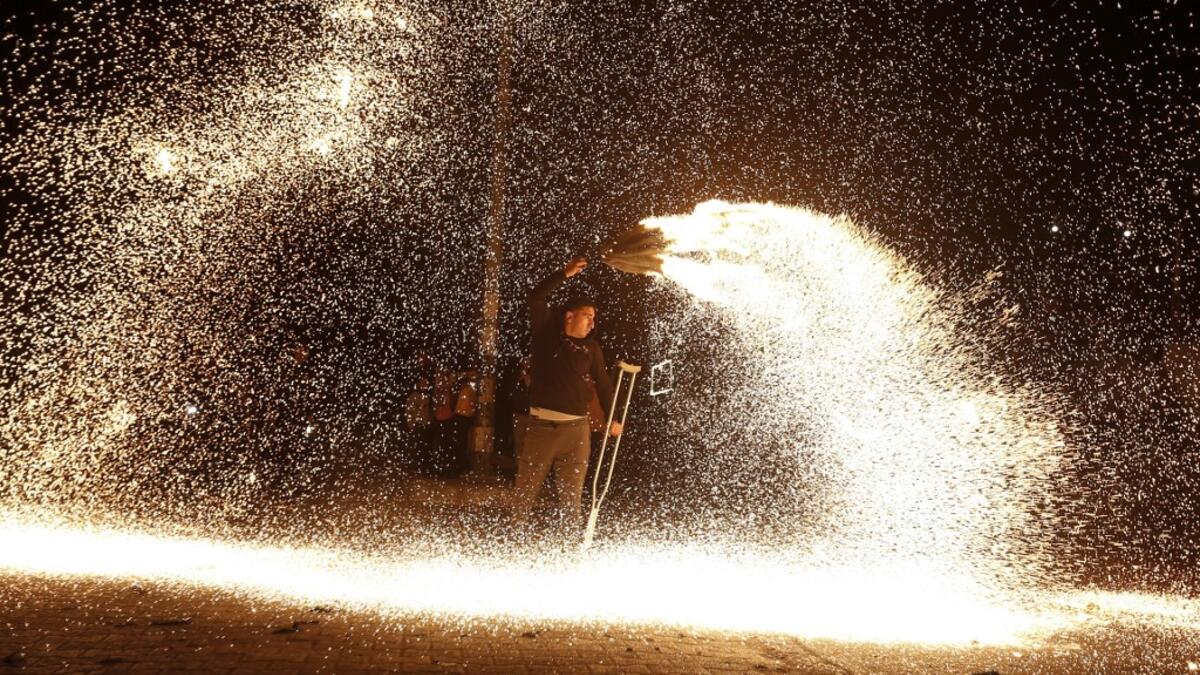 A Palestinian youth swings a homemade sparkler firework as people celebrate on a night of the Muslim holy month of Ramadan in Rafah refugee camp, in the southern Gaza Strip, on May 4, 2020. MAHMUD HAMS / AFP