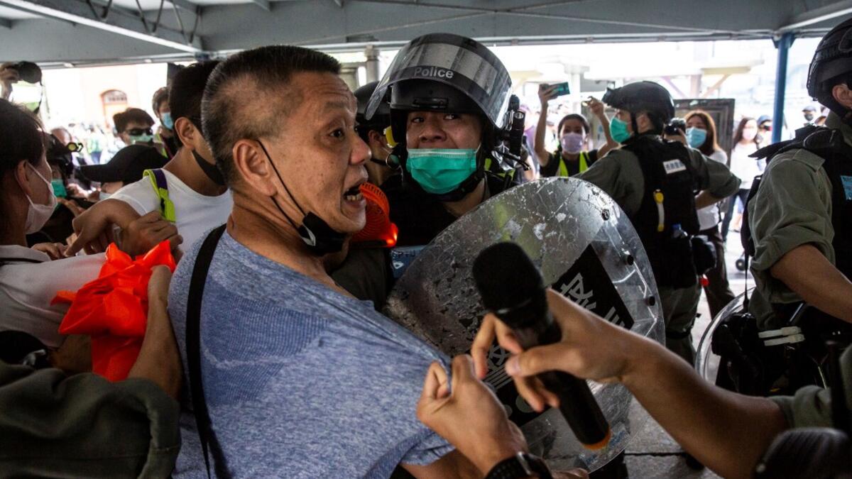 Police officers clash with a pro-democracy demonstrator (C) in the Tsim Sha Tsui waterfront during a pro-democracy protest calling for the city's independence in Hong Kong on May 10, 2020. ISAAC LAWRENCE / AFP