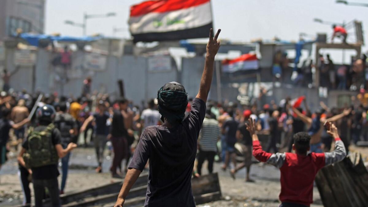 An Iraqi protester gestures the victory sign as some clash with security forces on Al-Jumhuriyah bridge in the capital Baghdad, during an anti-government demonstration on May 10,2020. Modest anti-government rallies resumed in some Iraqi cities today, clashing with security forces and ending months of relative calm just days after Prime Minister Mustafa Kadhemi's government came to power. AHMAD AL-RUBAYE / AFP