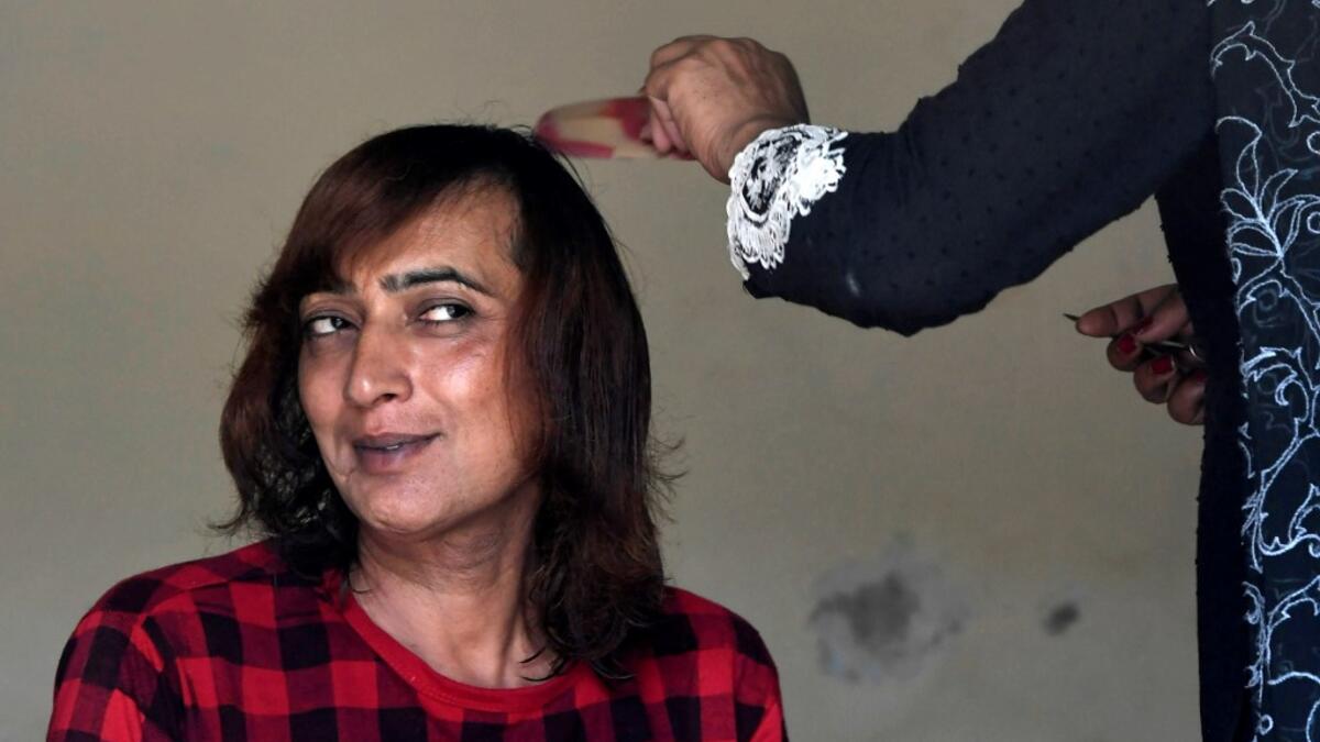 In this picture taken on May 10, 2020, Nadeem Kashish, a member of the transgender community, gets a haircut at a shelter house in Bari Imam neighbourhood of Islamabad. Transgender people in the country are known as "khawajasiras" or "hijras" -- an umbrella term denoting a third sex that includes transgender women and cross-dressers. Pakistan became one of the first countries in the world to legally recognise a third sex in 2009 and began issuing transgender passports from 2017. Aamir QURESHI / AFP