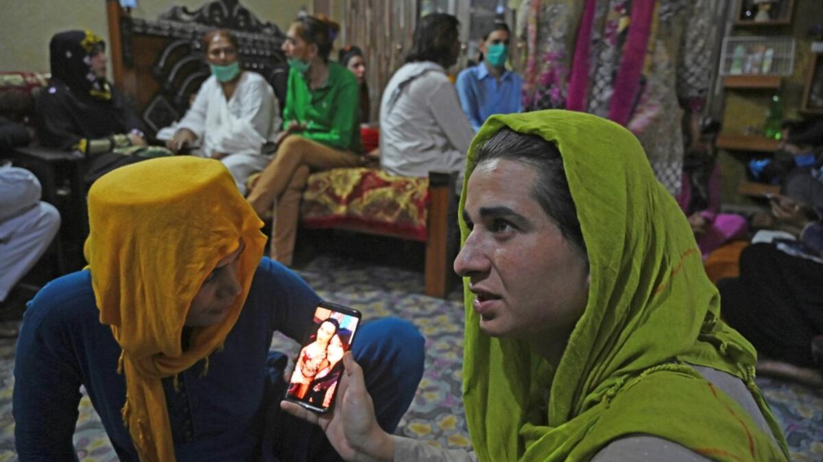 In this picture taken on May 9, 2020, members of the transgenders community gather to break their fast during the Islamic holy month of Ramadan at the Guru transgender house in Rawalpindi. Transgender people in the country are known as "khawajasiras" or "hijras" -- an umbrella term denoting a third sex that includes transgender women and cross-dressers. Pakistan became one of the first countries in the world to legally recognise a third sex in 2009 and began issuing transgender passports from 2017. Aamir QU