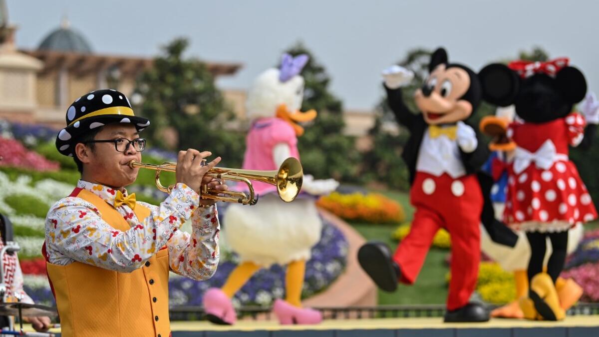 A musician performs during the reopening of the Disneyland amusement park in Shanghai on May 11, 2020. Disneyland Shanghai reopened on May 11 to the public after being closed since January due to the COVID-19 coronavirus outbreak. Hector RETAMAL / AFP
