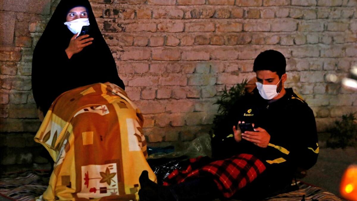 Iranians wearing face masks against the Covid-19 coronavirus attends Laylat al-Qadr prayers, one of the holiest nights during the Muslim fasting month of Ramadan, outside a mosque in the Tehran, on May 13, 2020. ATTA KENARE / AFP