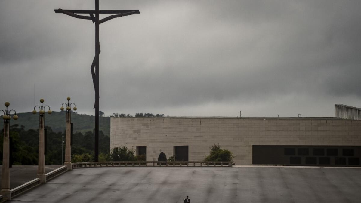 A lone man stands at the Fatima sanctuary during the 103rd anniversary of the apparitions of Our Lady Fatima in central Portugal on May 13, 2020. Without the crowd of pilgrims it welcomes every year, the shrine of Fatima celebrated the anniversary during a religious ceremony reduced to the bare minimum. PATRICIA DE MELO MOREIRA / AFP