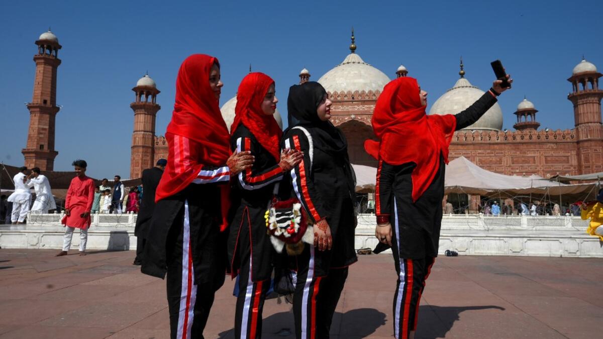 Muslim women take selfies after offering Eid al-Fitr prayers at the Badshahi Mosque in Lahore on May 24, 2020. Muslims around the world began marking a sombre Eid al-Fitr on May 24, many under coronavirus lockdown, but lax restrictions offer respite to worshippers in some countries despite fears of skyrocketing infections. Arif ALI / AFP
