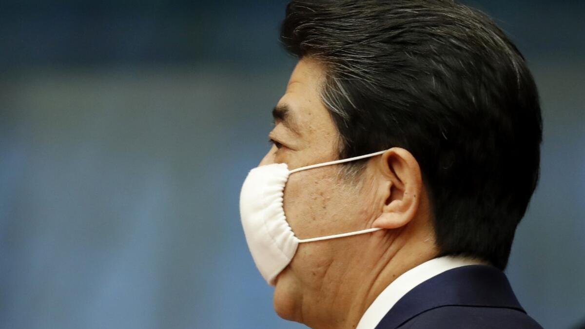 Japan's Prime Minister Shinzo Abe wears a face mask as he enters a venue for his news conference in Tokyo on May 25, 2020. Japan lifted a nationwide state of emergency over the coronavirus on May 25, gradually reopening the world's third-largest economy as government officials warned caution was still necessary to prevent another wave. KIM KYUNG-HOON / POOL / AFP