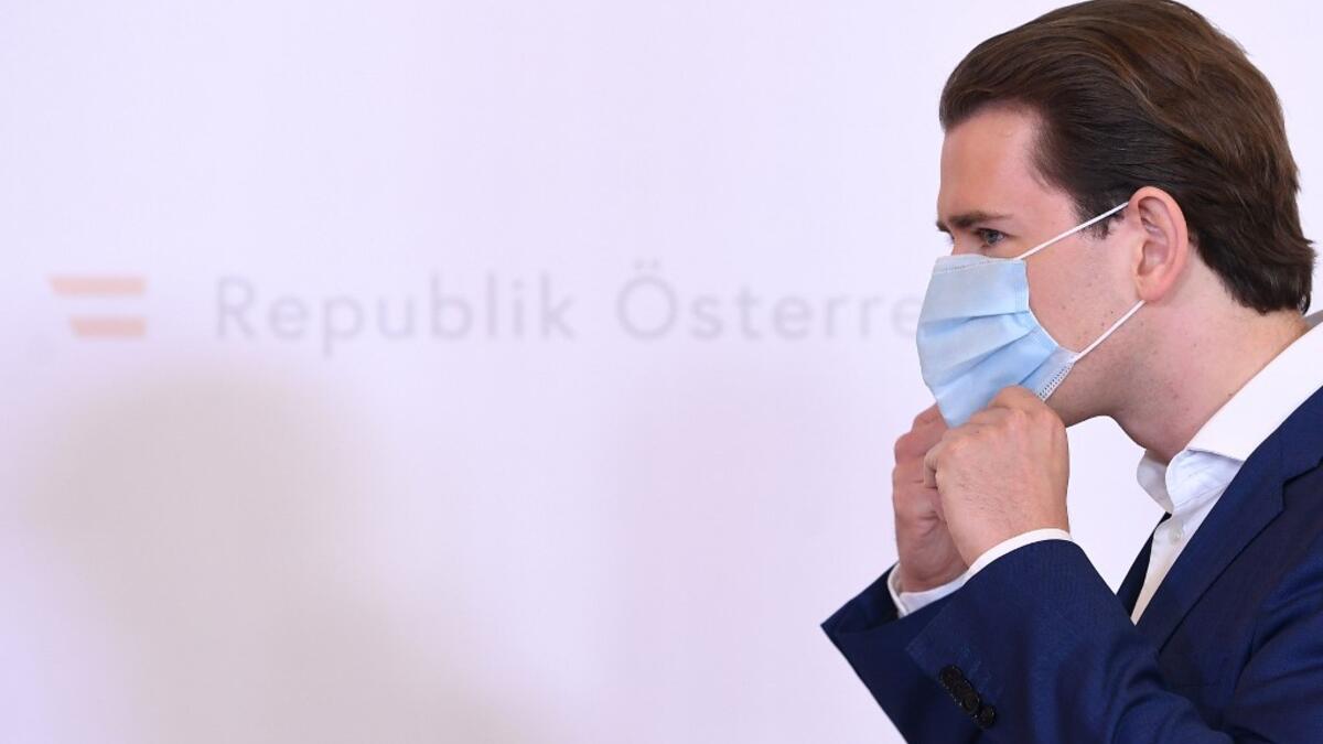 Sebastian Kurz, Austria's Chancellor and leader of Austria's People's party (OeVP), takes his face protection mask off as he arrives to give a press conference at the Chancellery in Vienna, amid the novel coronavirus / COVID-19 pandemic on May 25, 2020. HELMUT FOHRINGER / APA / AFP
