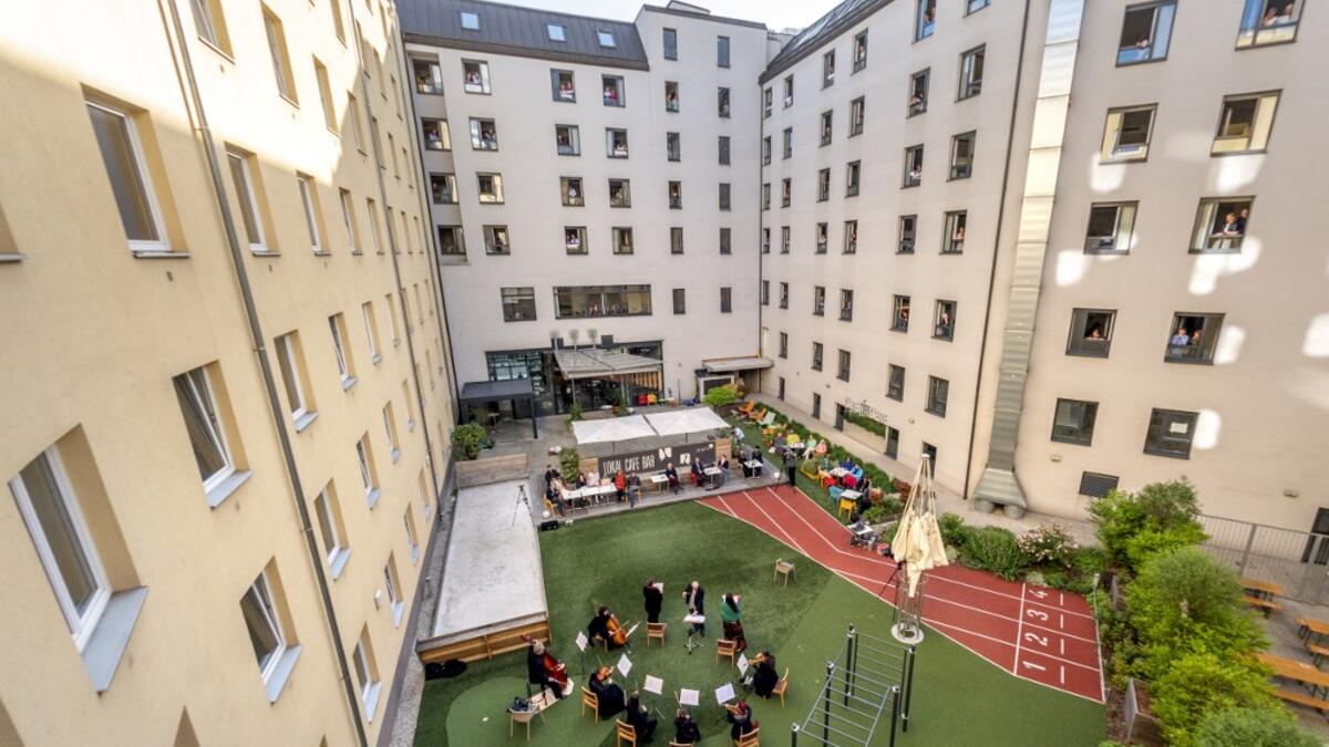 Guests of Zeitgeist Hotel listen from their rooms to singers Monika Medek and Dagmar Dekanovsky and the Camerata Carnutum orchestra, during a window concert (Fensterkonzert) in Vienna on May 30, 2020, as hotels have reopened in Austria amid the novel coronavirus pandemic. JOE KLAMAR / AFP