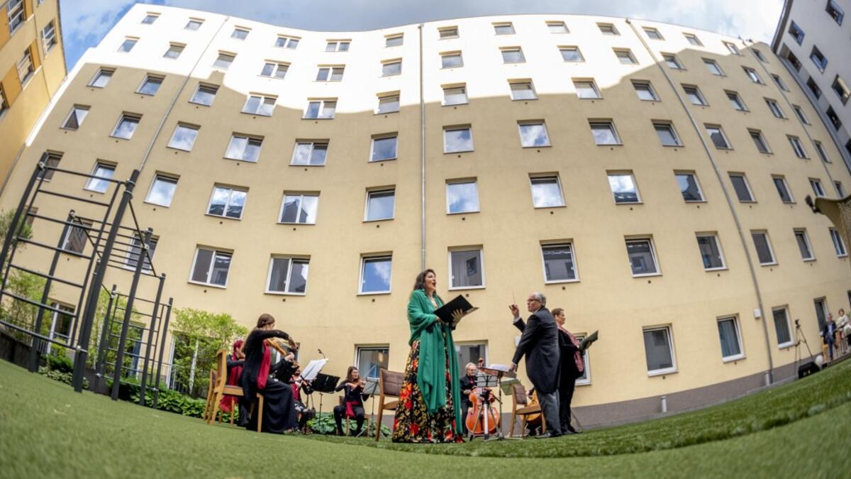 Guests of Zeitgeist Hotel listen from their rooms to singers Monika Medek and Dagmar Dekanovsky and the Camerata Carnutum orchestra, during a window concert (Fensterkonzert) in Vienna on May 30, 2020, as hotels have reopened in Austria amid the novel coronavirus pandemic. JOE KLAMAR / AFP