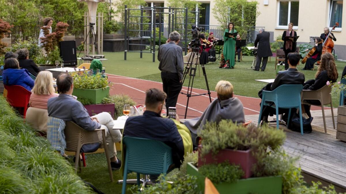 Guests of Zeitgeist Hotel listen to singers Monika Medek and Dagmar Dekanovsky and the Camerata Carnutum orchestra, during a window concert (Fensterkonzert) in Vienna on May 30, 2020, as hotels have reopened in Austria amid the novel coronavirus pandemic. JOE KLAMAR / AFP