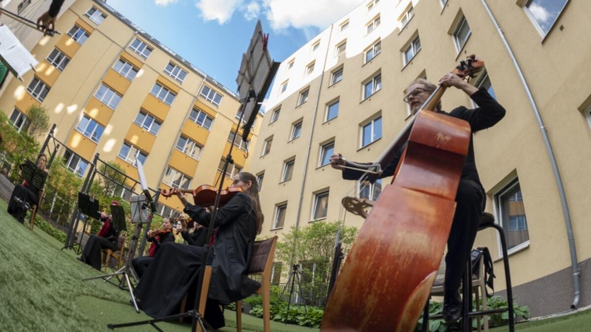Guests of Zeitgeist Hotel listen from their rooms to singers Monika Medek and Dagmar Dekanovsky and the Camerata Carnutum orchestra, during a window concert (Fensterkonzert) in Vienna on May 30, 2020, as hotels have reopened in Austria amid the novel coronavirus pandemic. JOE KLAMAR / AFP