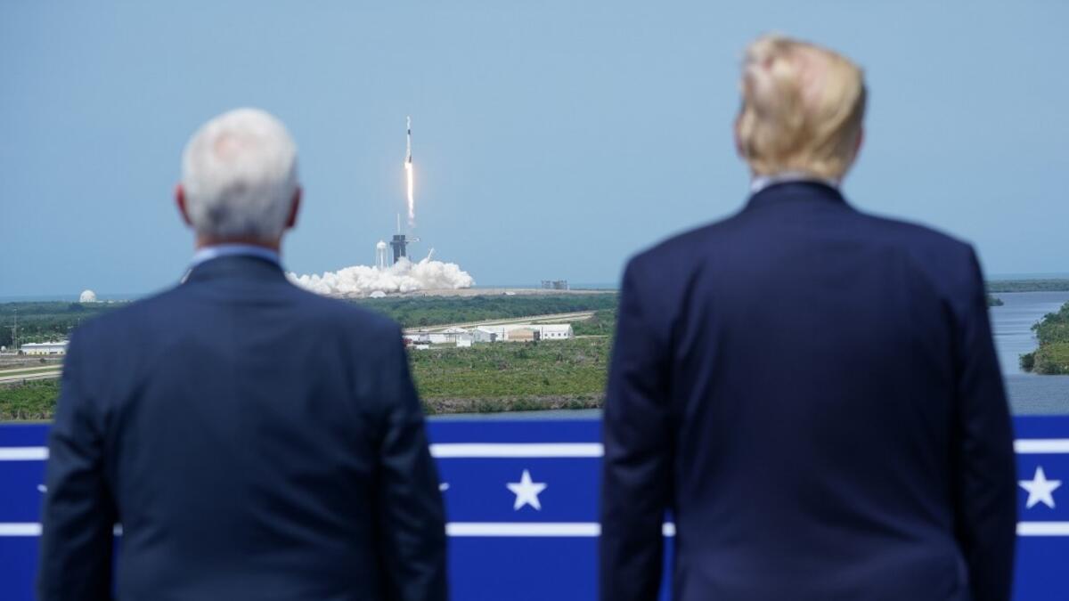 US President Donald Trump watches the SpaceX Falcon 9 rocket carrying the SpaceX Crew Dragon capsule, with astronauts Bob Behnken and Doug Hurley, lifts off from Kennedy Space Center in Florida on May 30, 2020. Trump travels to Kennedy Space Center in Florida to watch the launch of the manned SpaceX Demo-2 mission to the International Space Station. MANDEL NGAN / AFP
