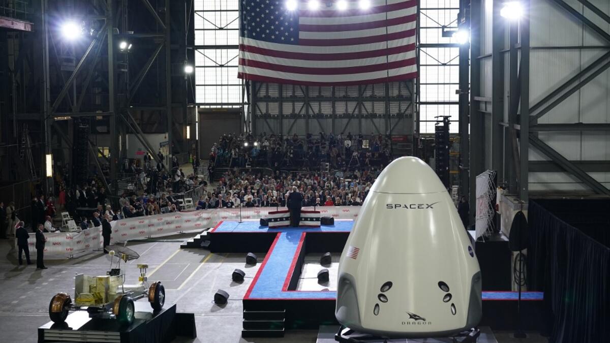 US President Donald Trump speaks near a SpaceX Crew Dragon capsule at a press briefing after the launch of the SpaceX Falcon 9 rocket and Crew Dragon spacecraft on NASA's SpaceX Demo-2 mission to the International Space Station from NASA's Kennedy Space Center in Cape Canaveral, Florida on May 30, 2020. Trump travels to Kennedy Space Center in Florida to watch the launch of the MANDEL NGAN / AFP